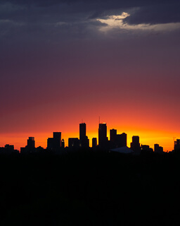 a vivid sunset behind the Minneapolis skyline